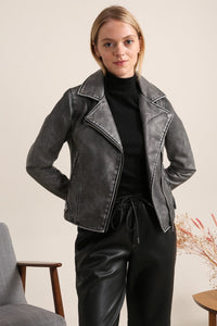 Modelo veste casaco cruzado GRINE curto em PU com efeito preto lavado e gola de lapela, estilo casual e elegante.