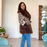 Modelo veste casaco GRINE com padrão de leopardo e detalhes em pêlo castanho, ideal para coordenados de inverno.