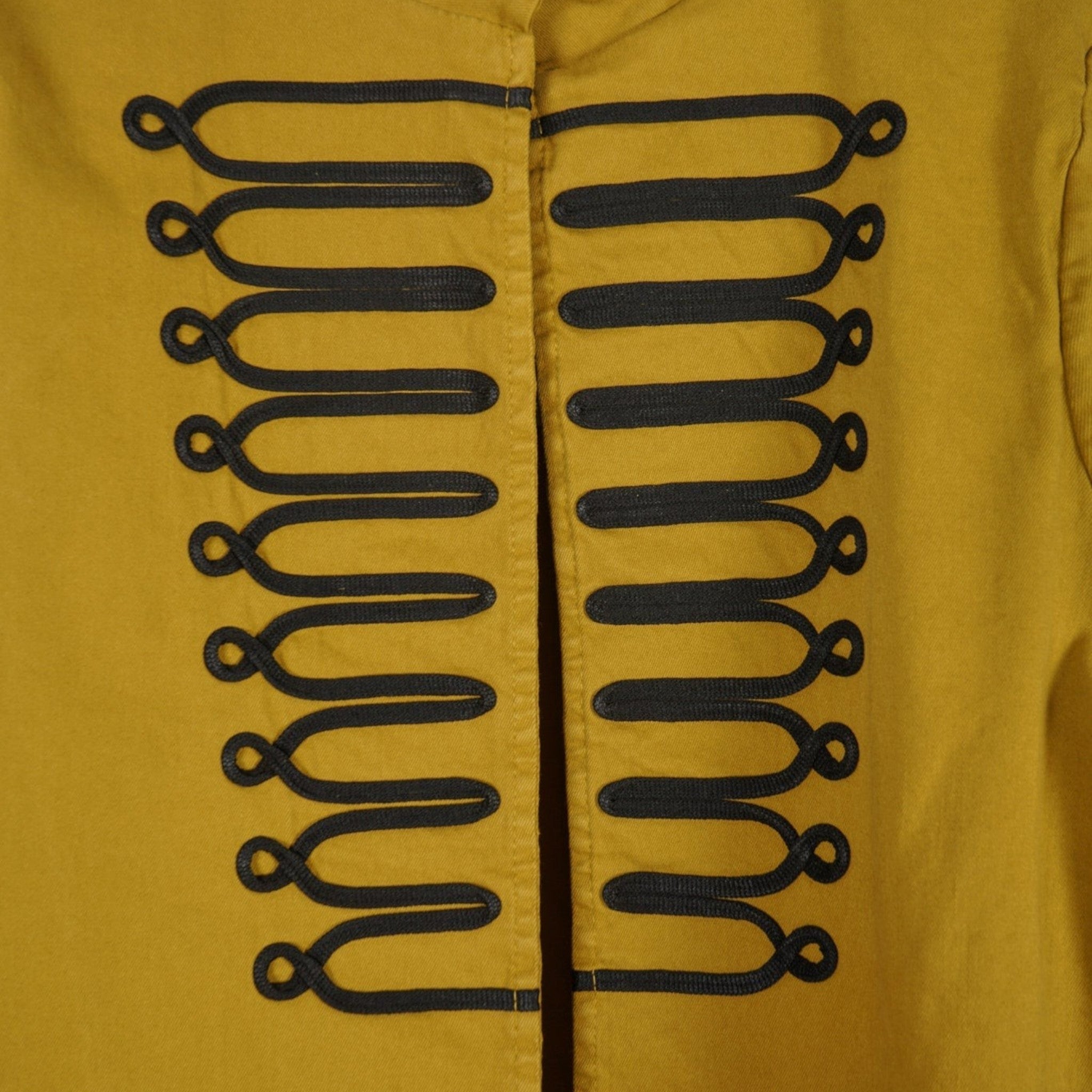 Casaco GRINE amarelo mostarda de estilo militar com alamares pretos em relevo e gola mao, em algodão e elastano.