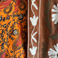 Detalhe de casaco Grine em veludo camel com bordados florais e interior em algodão estampado estilo blockprint.