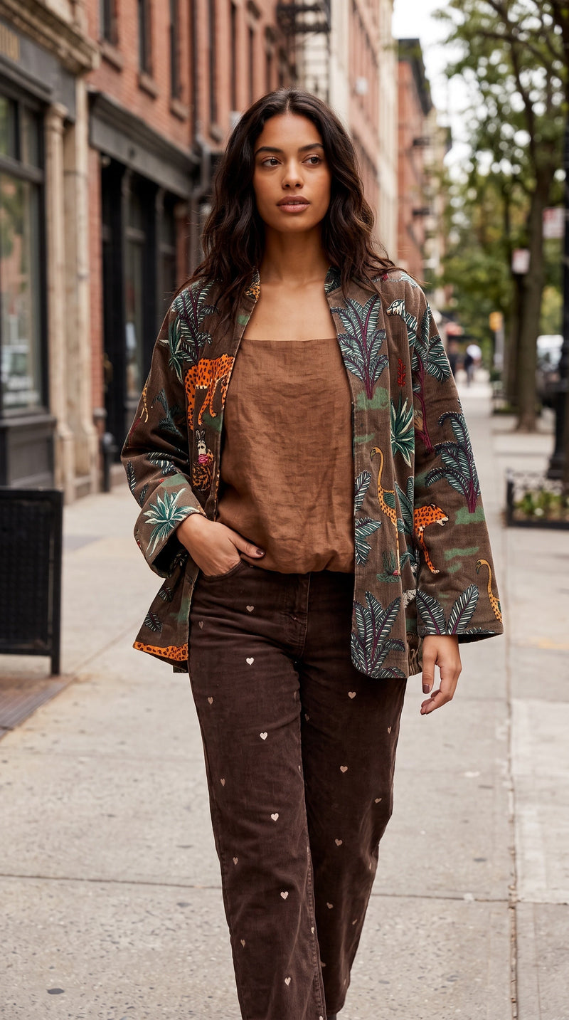Modelo veste casaco de veludo GRINE castanho com bordados florais e animais, estilo boémio, em ambiente urbano.