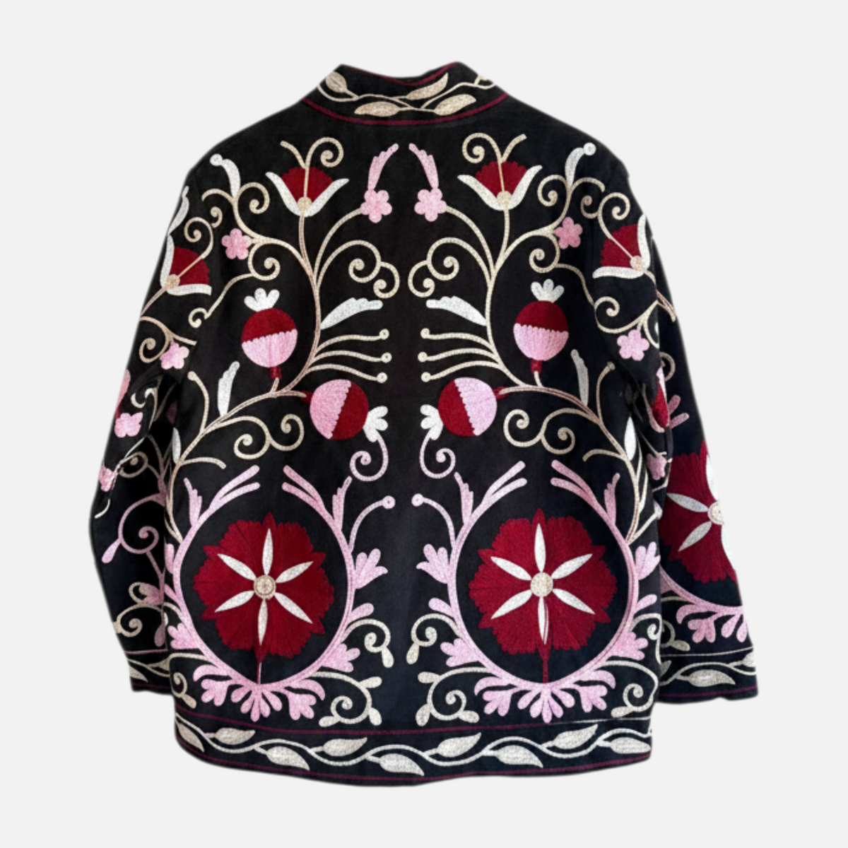 Casaco Grine de veludo preto com bordados florais estilo Suzani em tons de rosa e vermelho, vista traseira.