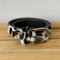 Cinto GRINE de couro com padrão animal print leopardo em tons de branco, preto e castanho com fivela prateada.
