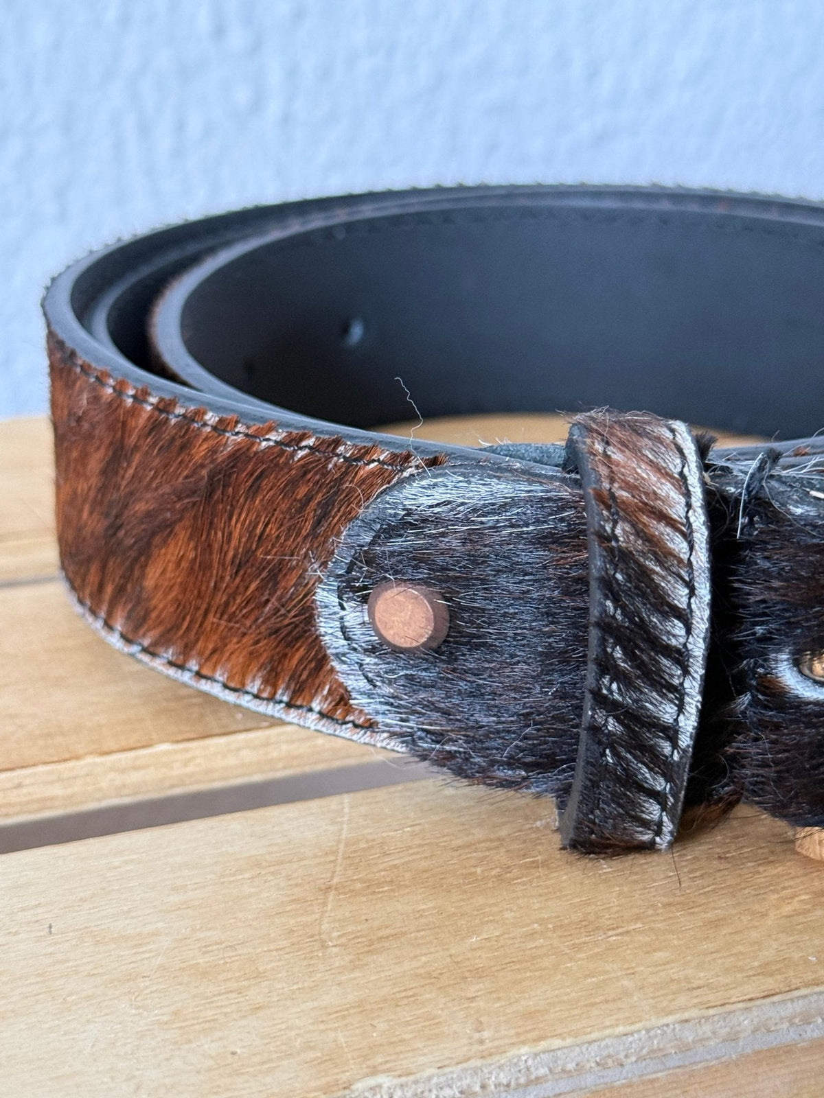 Cinto GRINE de couro com textura de pelo de vaca castanho e preto, 3,5 cm de largura, detalhe de rebite metálico.