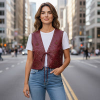 Mulher veste colete GRINE em PU bordeaux com bordados e tachas, fechado com atilho, em ambiente urbano.