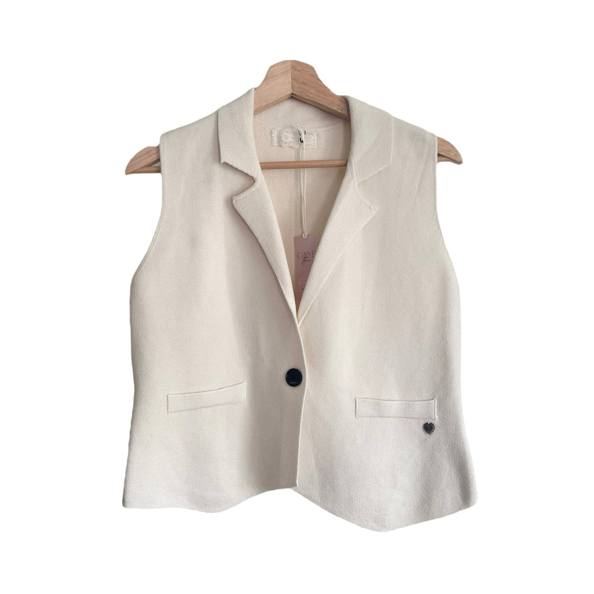 Colete de malha bege GRINE com lapelas, fecho de botão único e detalhe de coração, estilo casual e sofisticado.