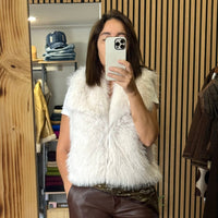 Mulher a usar colete de pêlo branco elegante da marca GRINE, ideal para um look sofisticado e quente.