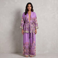 Modelo veste conjunto GRINE roxo com kimono e calças wide leg em viscose com padrão paisley boho chic.