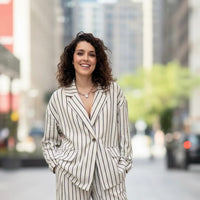 GRINE Goreti oversized beige linen blend blazer with black pinstripes and button front. Model wears it with matching trousers.