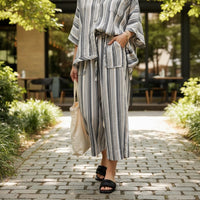 GRINE grey wide-leg trousers with elasticated waist, side pockets, and a vertical stripe pattern. Made from a rayon, polyester, and cotton blend.