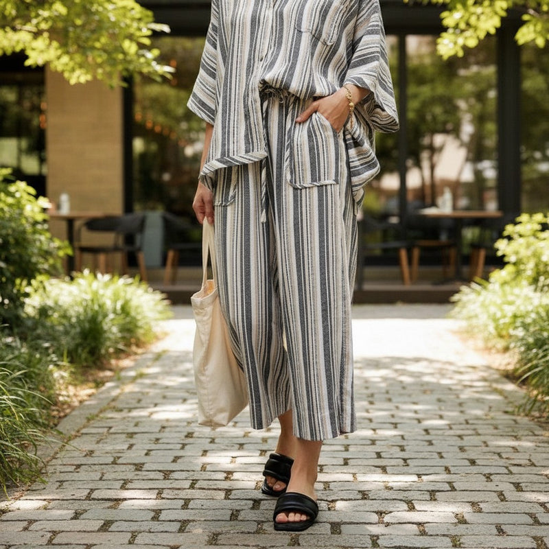 GRINE grey wide-leg trousers with elasticated waist, side pockets, and a vertical stripe pattern. Made from a rayon, polyester, and cotton blend.