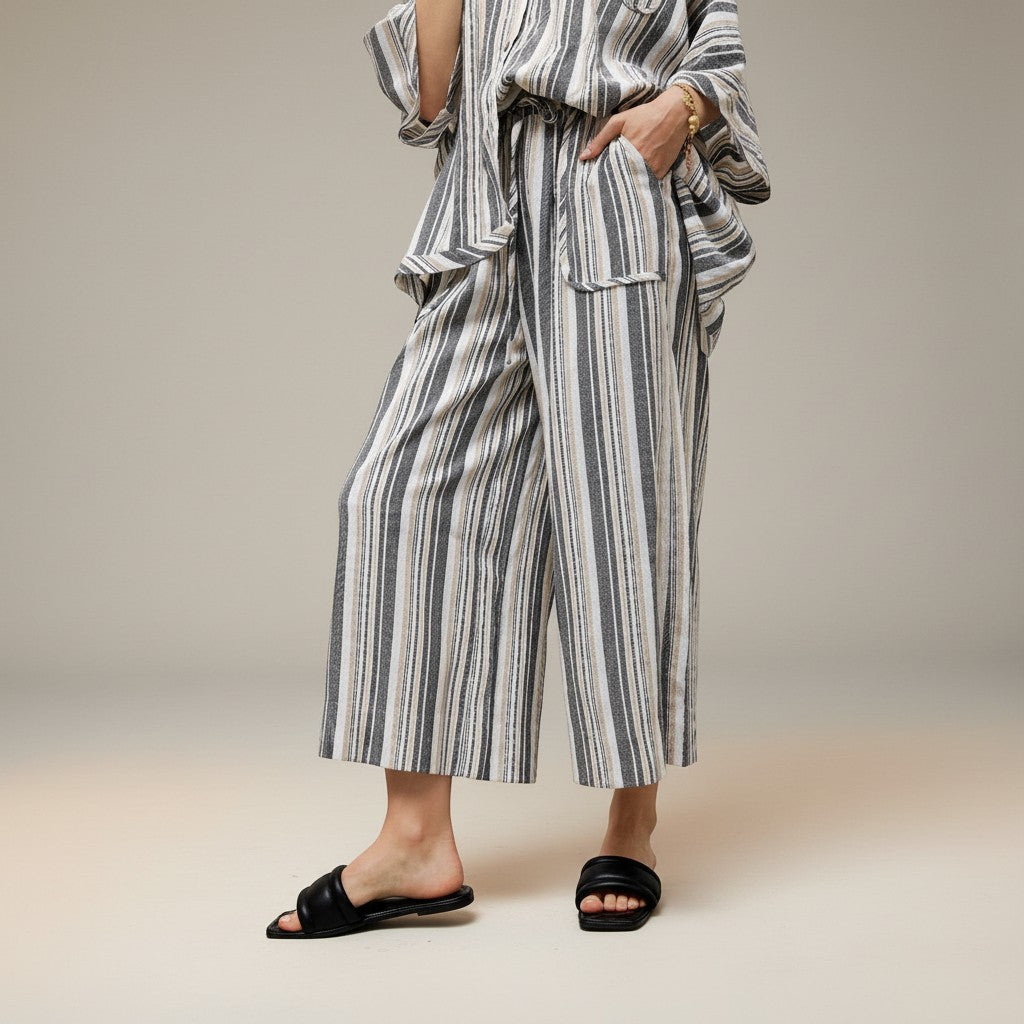 GRINE grey wide-leg trousers with elasticated waist, side pockets, and vertical stripe pattern. Made from a rayon, polyester, and cotton blend.