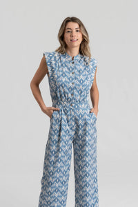 Jardineiras azuis GRINE com padrão ikat, corte direito, gola subida e bolsos laterais, vestidas por uma modelo.