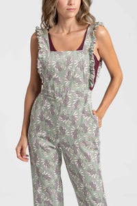 Jardineiras GRINE verdes com padrão floral, alças com folhos e corte direito, vestidas por uma modelo.