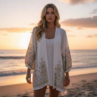 GRINE Kimono branco com bordados dourados nas mangas e bainha, corte solto, ideal para praia ou look boho chic.