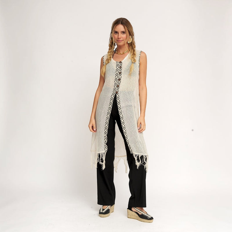 GRINE Kimono Brisa em rede bege com padrão geométrico preto, botões de coco e franjas na bainha. Peça versátil para dias quentes.