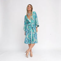GRINE Kimono de seda azul claro com padrão paisley bordado, cinto e fendas laterais. Peça de resort wear.