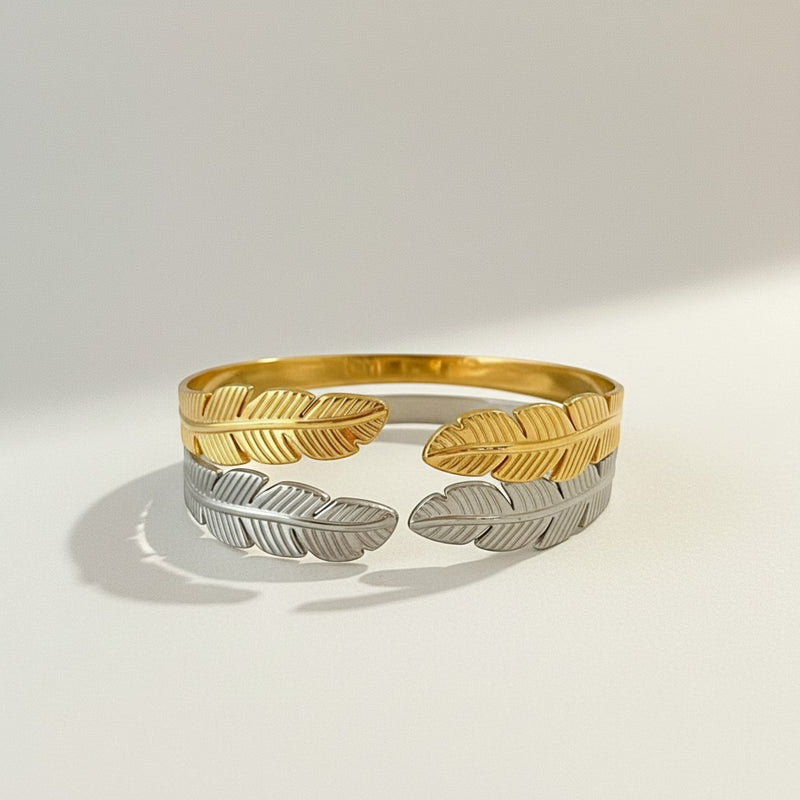 GRINE gold and silver stainless steel cuff bracelet with leaf design. Adjustable and hypoallergenic.