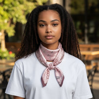 Modelo usa lenço quadrado acetinado GRINE na cor rosa velho com estampa delicada amarrado ao pescoço