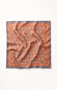 Lenço quadrado acetinado GRINE na cor tijolo com padrão paisley, ideal para usar no pescoço ou cabelo.