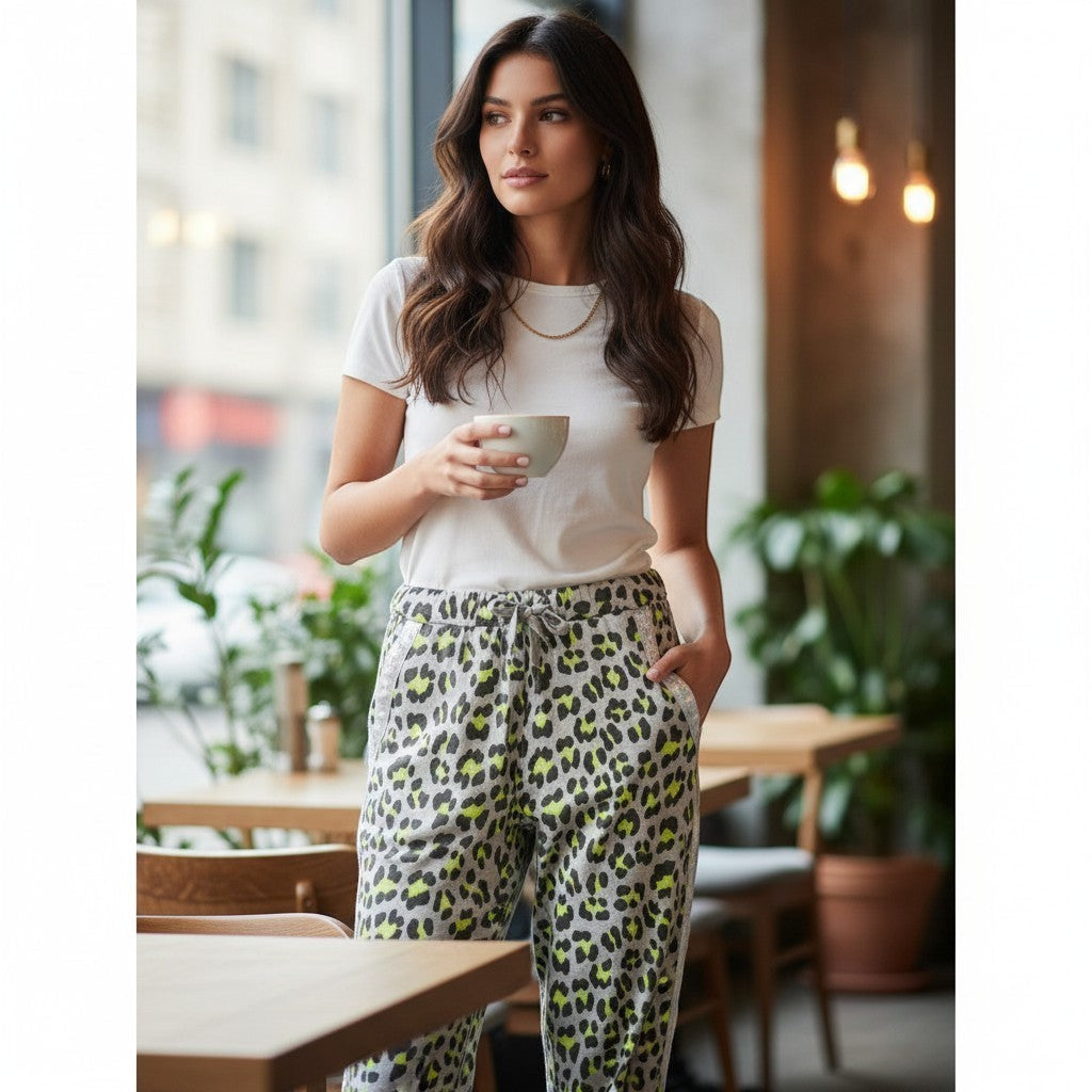 GRINE leopard print jogger pants with elastic waist and drawstring, made of cotton with stretch. Grey with neon yellow spots.