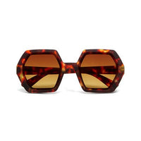 Óculos de sol GRINE OKKIA EMMA com armação hexagonal em padrão tartaruga Classic Havana e lentes castanhas degradé.