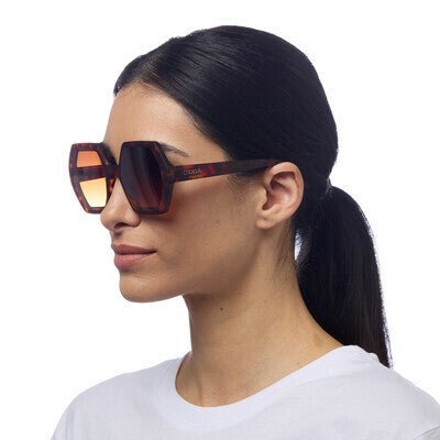 Modelo usa óculos de sol GRINE OKKIA EMMA com armação castanha tartaruga e lentes degradé polarizadas