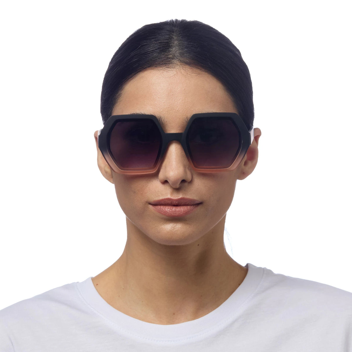 Modelo usa óculos de sol GRINE OKKIA EMMA com armação geométrica preta e rosa e lentes degradê em fundo branco