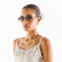 Modelo usa óculos de sol OKKIA ANDREA com armação em acetato amarelo e castanho e lentes degradé polarizadas