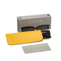 Óculos de sol OKKIA ELBA pretos com estojo amarelo e pano de limpeza, marca GRINE