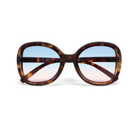 Óculos de sol GRINE OKKIA Monica com armação redonda oversized em padrão Havana e lentes degradé azul e rosa.