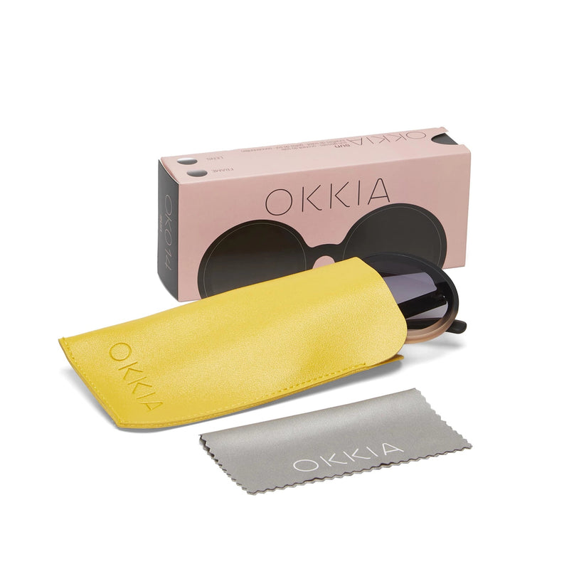 Óculos de sol redondos pretos OKKIA MONICA com caixa rosa, bolsa amarela e pano de limpeza da marca GRINE