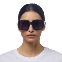 Modelo usando óculos de sol GRINE OKKIA ALESSIA pretos com armação em acetato e lentes degradé polarizadas