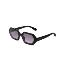 Óculos de sol GRINE OKKIA ANDREA com armação hexagonal preta e lentes degradé, acabamento soft touch.