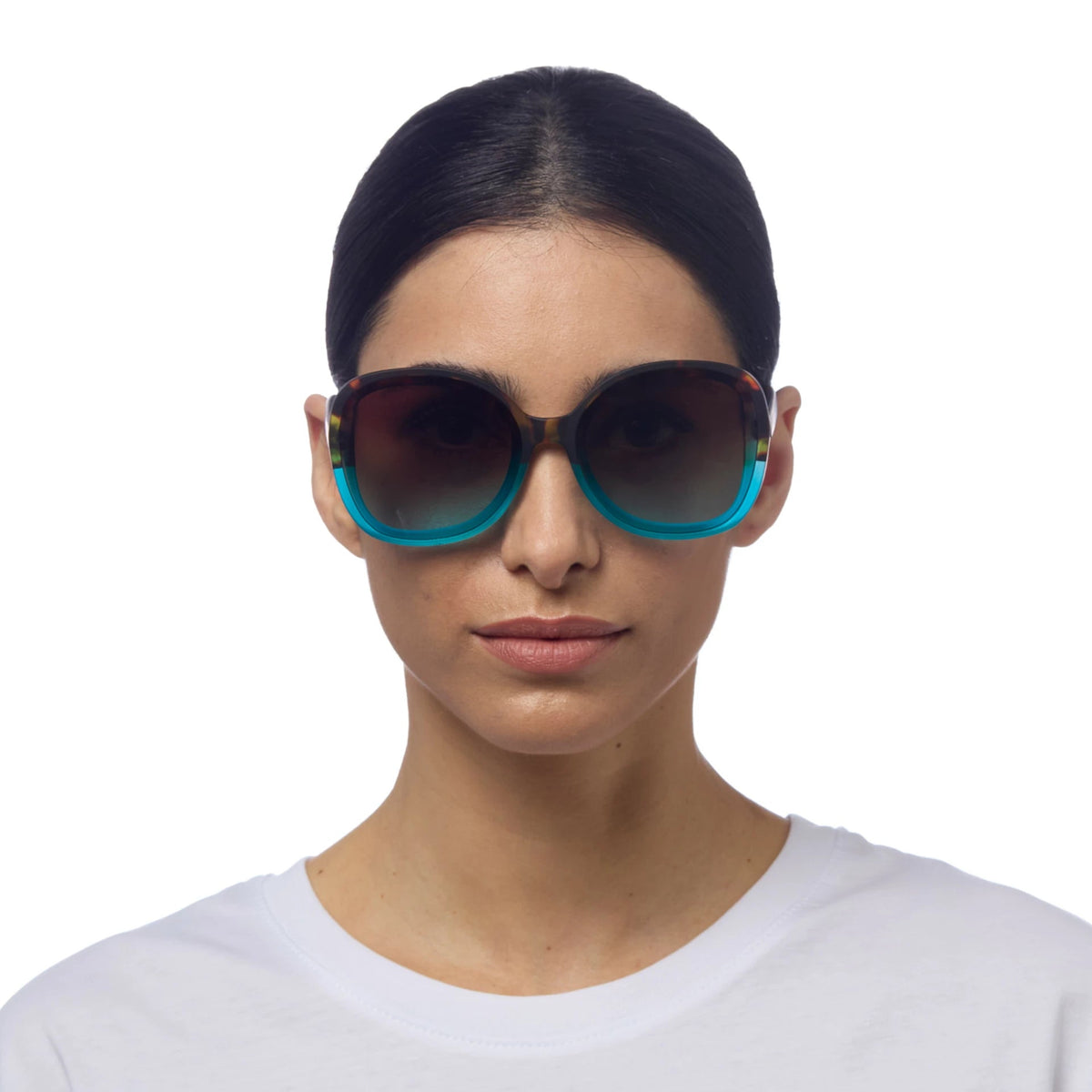 Mulher a usar óculos de sol GRINE OKKIA ANNA com armação tartaruga e azul e lentes castanhas degradé polarizadas