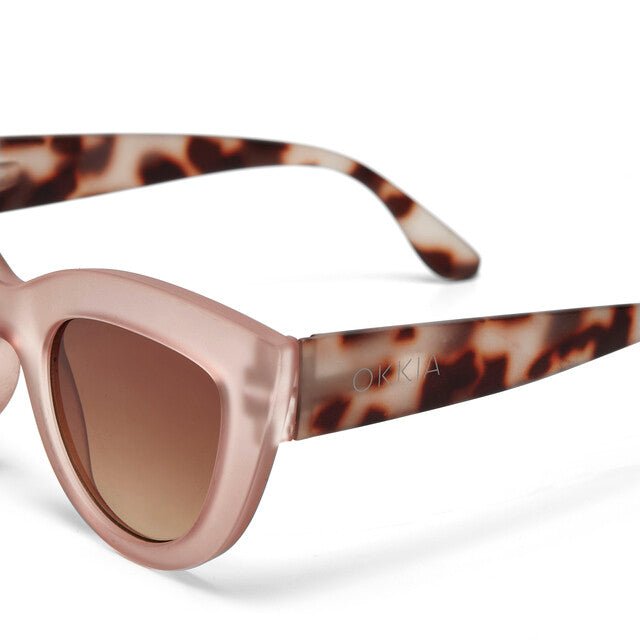 Óculos de sol GRINE OKKIA CLAUDIA com armação estilo Big Cat Eye em tom Pink Havana e lentes castanhas.