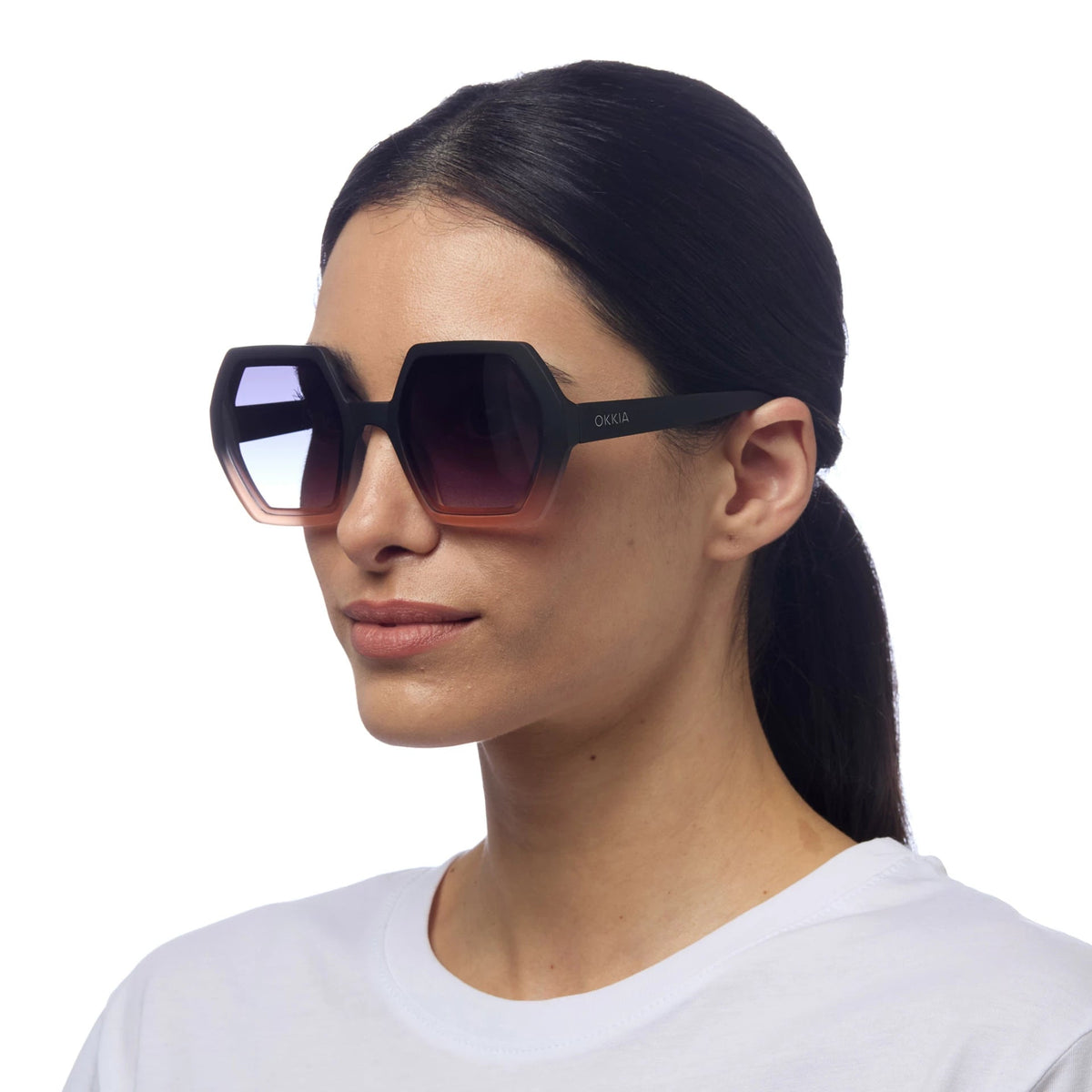 Mulher a usar óculos de sol GRINE OKKIA EMMA com armação preta e rosa em acetato e lentes polarizadas degradê