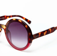 Óculos de sol GRINE OKKIA MONICA redondos com armação em padrão tartaruga e rosa e lentes castanhas polarizadas.