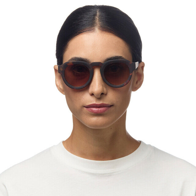 Mulher a usar óculos de sol GRINE OKKIA ZENO com armação Classic Havana em acetato e lentes castanhas polarizadas