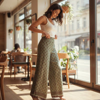 GRINE olive green wide-leg trousers with brown polka dots and a decorative border at the hem. Lightweight cotton fabric, ideal for warm weather.