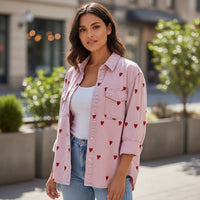 GRINE pink denim shirt jacket with red embroidered hearts, long sleeves, button-down front, and chest pockets.