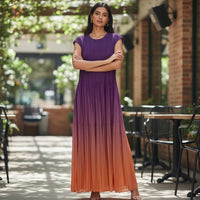 GRINE long pleated dress with a purple to orange gradient effect, sleeveless with a slightly structured shoulder.