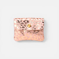 Porta-moedas GRINE em camurça rosa com padrão animal print dourado e fecho de botão metálico