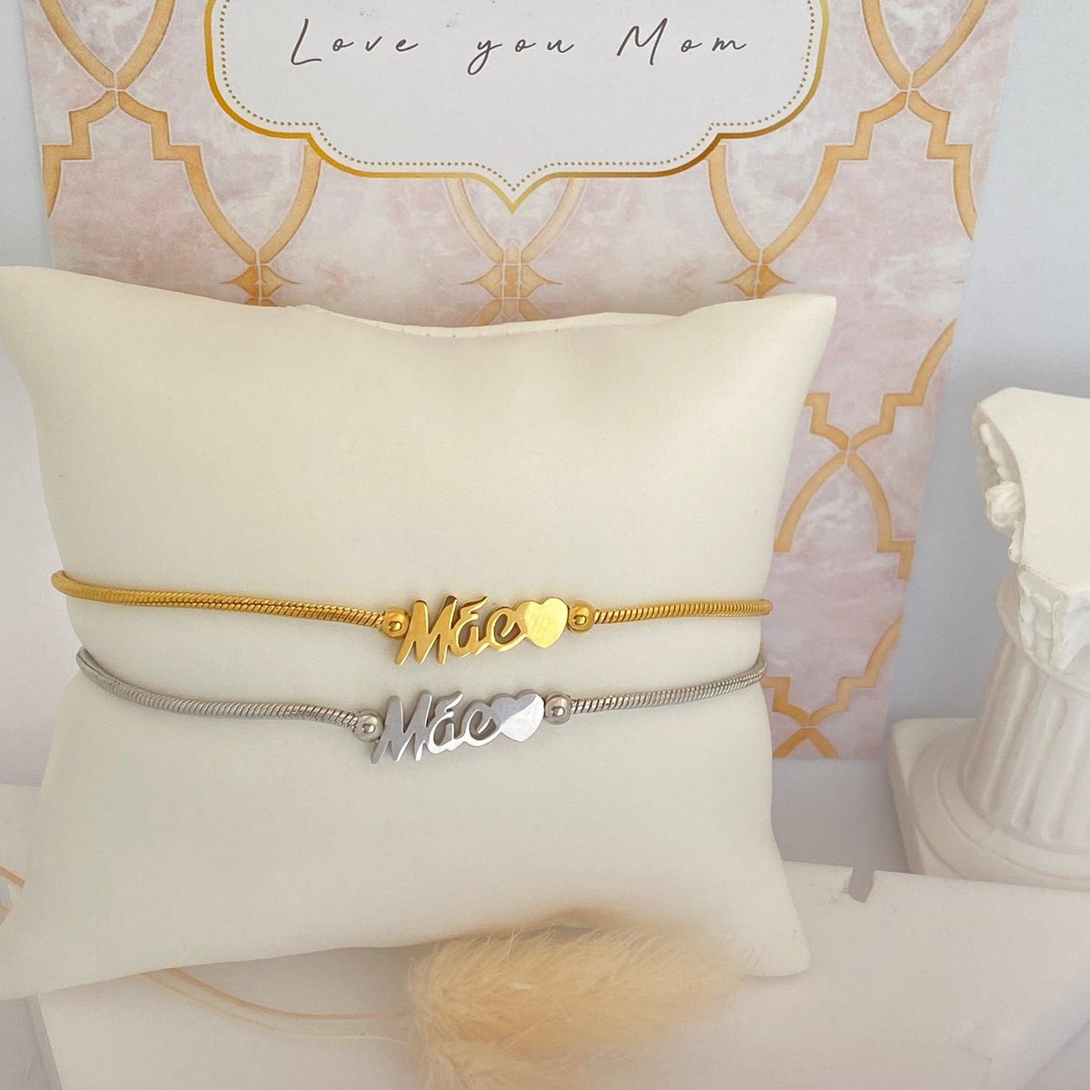 Pulseiras ajustáveis GRINE em aço inoxidável com a palavra Mãe e detalhe de coração em tons dourado e prateado
