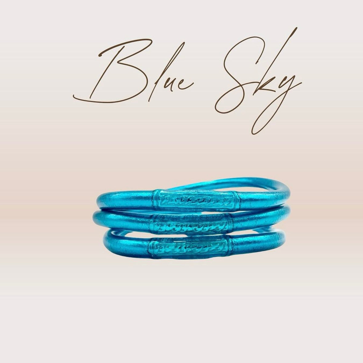 Pulseira GRINE azul flexível com folha de ouro e conector de cobre gravado com mantra budista de sorte e amor.