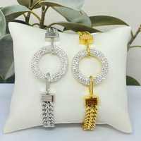 Pulseira Circle GRINE em aço inoxidável com pendente circular cravejado de strass, disponível em dourado e prateado.