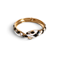 Pulseira rígida GRINE em forma de cobra com padrão geométrico esmaltado em preto e branco e acabamento dourado.