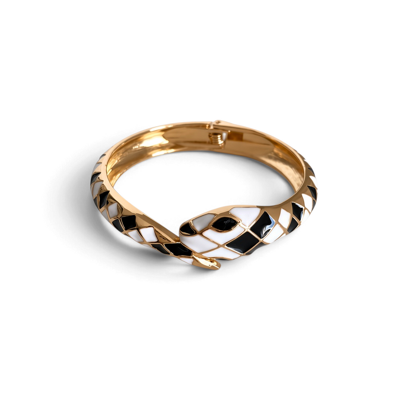 Pulseira rígida GRINE em forma de cobra com padrão geométrico esmaltado em preto e branco e acabamento dourado.