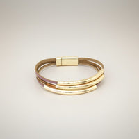 Pulseira Funky GRINE em pele sintética rosa e bronze com tubos metálicos dourados e fecho magnético hipoalergénico.