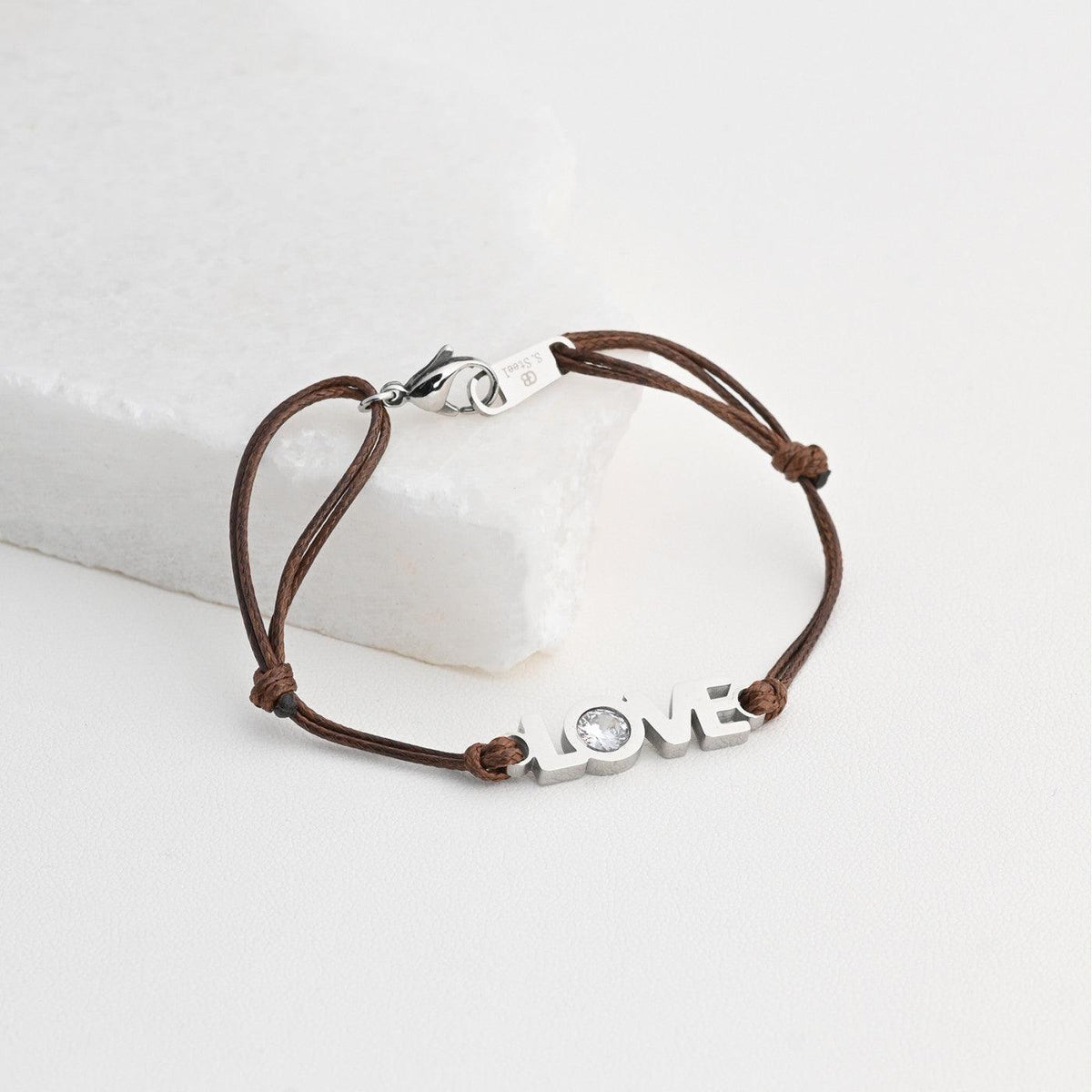 Pulseira GRINE LOVE em aço inoxidável castanha com detalhe brilhante e fecho ajustável sobre base de pedra branca
